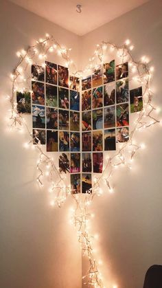 a heart shaped photo collage hanging on the wall with string lights in front of it