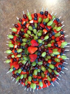 an arrangement of fruit arranged in the shape of a circle on a counter top with toothpicks