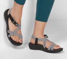 Ease back with strappy style and stretchable comfort in the SKECHERS Reggae - Irie Mon sandal.  Soft woven stretch fabric upper in a strappy toe thong river style sandal with stitching accents  quick closure and supportive comfort midsole. River Style, Orthotic Shoes, Diy Sandals, Orthopedic Sandals, Walking Shoes Women, Anarkali Dress, Skechers Women, Sport Sandals, Designer Sandals