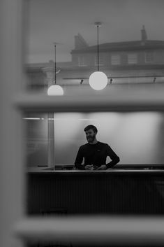 a man standing behind a counter in front of a window