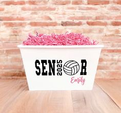 a white container filled with pink sprinkles on top of a wooden table