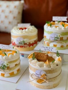 there are many cakes on the table with name tags attached to each cake and one has a slice taken out of it