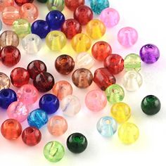 many different colored glass beads on a white surface with space for the word's logo