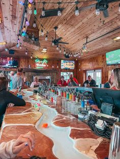 people are sitting at the bar with their laptops and drinks in front of them