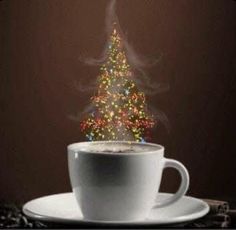 a cup of coffee with a lit christmas tree on top is sitting on a saucer