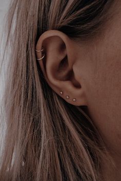 a close up of a person's ear with two small piercings on it