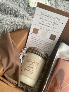 an open box containing a candle and some other items