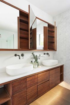 a bathroom with two sinks and large mirrors on the wall next to eachother