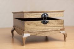 a small wooden box sitting on top of a wood table next to a drawer with two handles