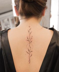 the back of a woman's neck is shown with a flower tattoo on it