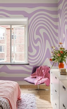 a bedroom with purple and white stripes painted on the wall next to a large window