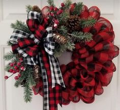 a red and black christmas wreath with pine cones