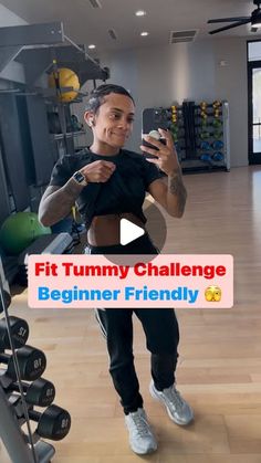 a man taking a selfie in the gym with his cell phone and dumbbells