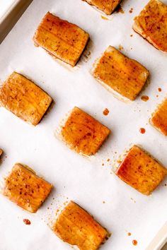 several pieces of food sitting on top of a baking sheet covered in brown sugar and seasoning