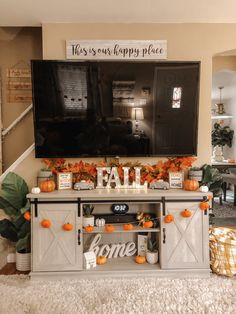 a flat screen tv mounted to the side of a wall next to a table with decorations on it