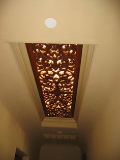 an overhead view of a toilet in a small room with light coming from the ceiling