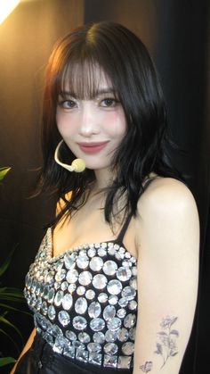 a woman in a black and white dress with a flower in her mouth is posing for the camera