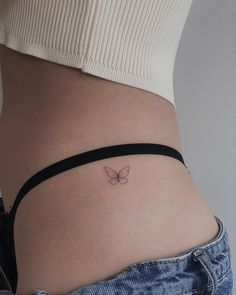 a woman's stomach with a small butterfly tattoo on the side of her belly