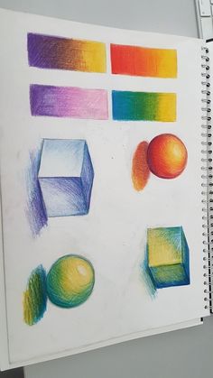 an open notebook with colored pencils on top of it and various shapes in the pages