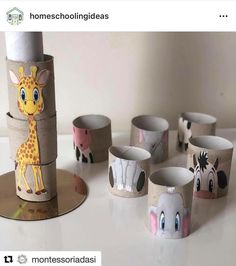 some toilet paper cups with animals on them and one has a giraffe in the middle