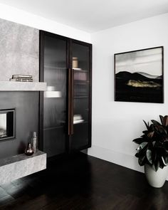 a living room with black and white walls, wood flooring and a large painting on the wall