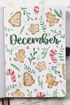 an open christmas planner with ginger cookies and candy canes on the cover, next to a pen