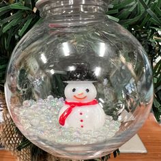 a snowman in a fish bowl on top of a table