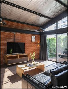 a living room with brick walls and large windows