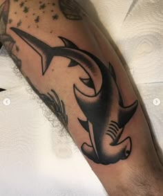 a man's arm with a shark tattoo on it and an arrow in the middle