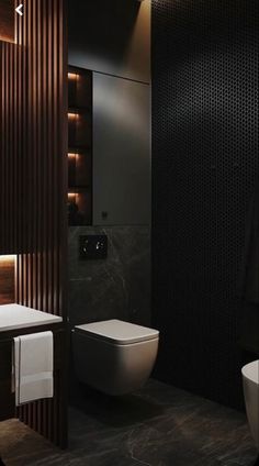 a bathroom with a toilet, sink and mirror in it's dark color scheme