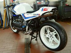 a white and blue motorcycle parked in a garage