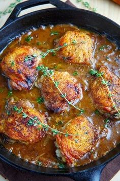 chicken thighs in gravy with fresh herbs on top