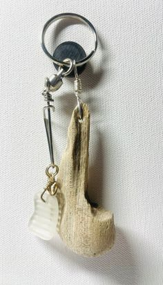 a piece of driftwood is attached to a keychain with a metal hook