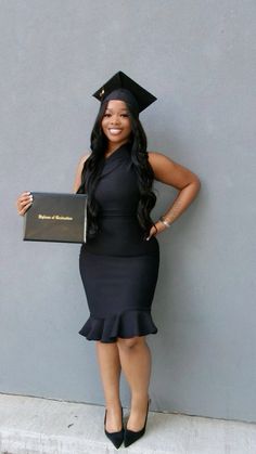 a woman in a graduation cap and gown holding a plaque with her name on it