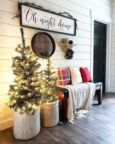 a small christmas tree in a white pot next to a couch and wall with a sign that says oh night above it