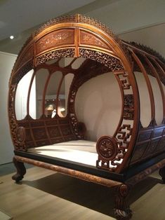 an ornate wooden bed frame on display in a museum