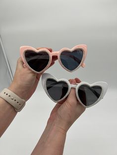 "Fun heart-shaped sunglasses with diamond trim are perfect for any bachelorette Party, Birthday Party, or any day out! These are handmade in two color options white or pink. IMPORTANT: One pair of sunglasses is included, Buy 5 or more and save 10% with coupon code \"PARTY10\"" Cute Party Sunglasses With Heart Print, Fun Party Sunglasses With Heart Print, Heart-shaped Sunglasses With Heart Print For Party, Heart-shaped Party Sunglasses With Heart Print, Cute Heart Print Sunglasses For Party, Fun Heart Print Party Sunglasses, White Heart-shaped Sunglasses For Valentine's Day, Pink Heart-shaped Party Sunglasses, Valentine's Day Party Sunglasses With Tinted Lenses