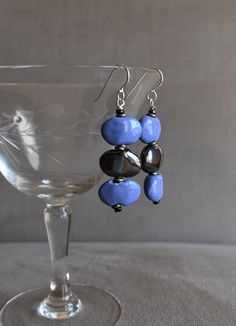 These earrings have Kenyan Kazuri Ceramic Beads in black and blue, with a high gloss glaze, which gives them a beautiful shine.  Kazuri is the Swahili word for 'small and beautiful'.  Each bead is made by hand, polished, fired, painted, then fired again so no two beads will be identical.   The earrings have a 2 1/4" drop, they have Sterling Ear Wires or Niobium Ear Wires ( if requested).    The Kazuri bead style used here is called Shale. The Kazuri 'Shale' beads are approximately 5/8" x 3/8" x 3/16" thick.  The ear wires are sterling or if you have metal allergies, Niobium will be provided.  Niobium has outstanding qualities including being nonreactive to those with sensitive skin or metal allergies.  Send a message to me with your order/payment if you require the Niobium wires. Please lo Adjustable Blue Earrings With Black Beads, Blue Dangle Earrings With Black Beads, Blue Dangle Jewelry With Black Beads, Kazuri Beads, Have Metal, Ceramic Beads, Bead Earrings, Ear Wires, Wire Jewelry