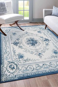 a blue and white area rug with an ornate design on the center, sitting in a living room