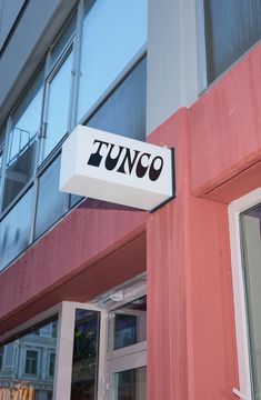 a pink building with a sign that says tunco on the front and side of it