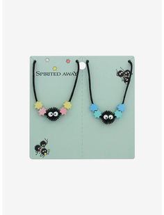 two necklaces with flowers on them are sitting in front of a white card that says spirited