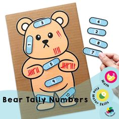 a hand holding up a bear math game with numbers on the front and back side