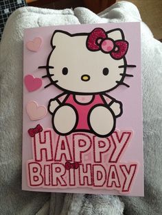 a hello kitty birthday card sitting on top of a bed