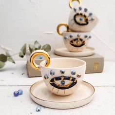 two cups and saucers decorated with gold rings