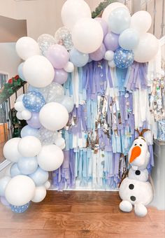 a frozen world birthday party with balloons, streamers and a snowman balloon decoration