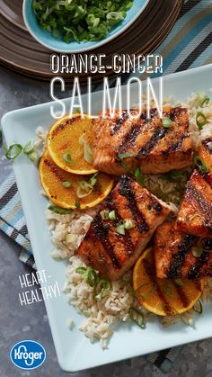 the cover of orange - ginger salmon is shown on a plate with rice and sliced oranges