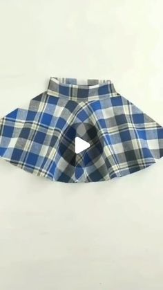 a blue and white checkered dog skirt with a bow at the bottom that has a small hole in it