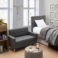 a bed room with a neatly made bed next to a chair and a footstool