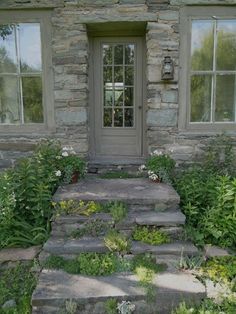 a stone house with steps leading to the front door