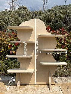 three wooden shelves are shown with measurements for each shelf in front of some bushes and shrubs